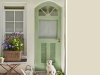 Little Greene - Green Stone Light 269 sur un mur extérieur avec une porte verte et un panier de fleurs
